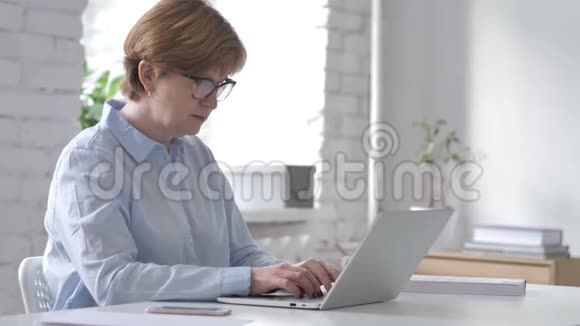 震惊惊魂未定的老妇人在笔记本电脑上徘徊视频的预览图