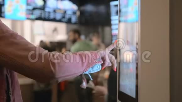 女士选择食品通过自助机在快餐店使用自助触摸终端的人视频的预览图