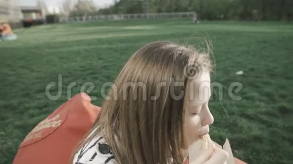 美少女吃大自然中国面条的特写镜头筷子坐在草坪上柔软的红色枕头上视频的预览图
