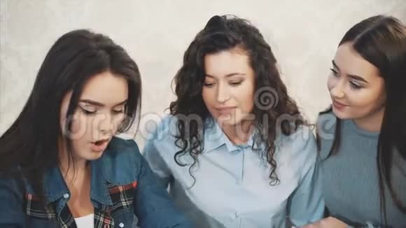 三个年轻的好女孩坐在咖啡馆里花时间交流视频的预览图