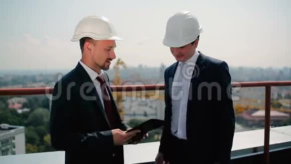 两个戴头盔的人在屋顶谈话视频的预览图