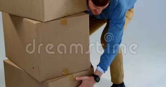 男子携带一叠纸板箱白色背景4k视频的预览图