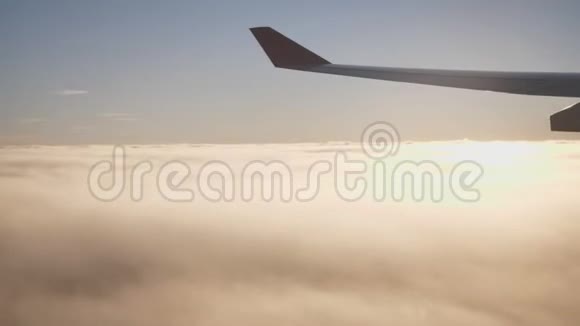 飞行和旅行日落时从机翼上的飞机窗口观看视频的预览图