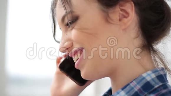 迷人而开朗的年轻女人在室内使用手机她在电话里说着笑快关门视频的预览图