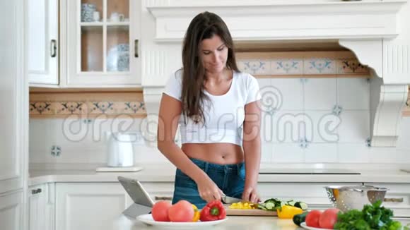 家庭主妇在家厨房用新鲜的有机蔬菜做素食沙拉视频的预览图