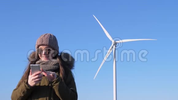 风力发电厂年轻女子手中拿着小玩意几乎能生产清洁的可再生能源视频的预览图