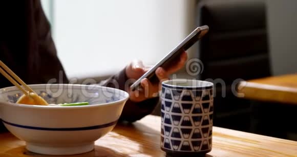 4k餐厅用手机吃面条的女人视频的预览图