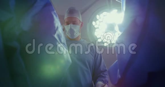 高加索男性外科医生在医院手术室做手术的低角度视角视频的预览图