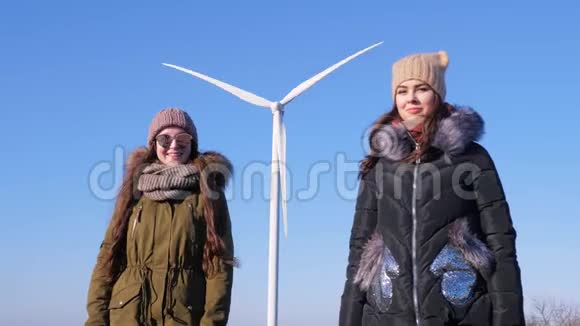 生产清洁的可再生能源可爱的女朋友走在风车旁露出手指视频的预览图