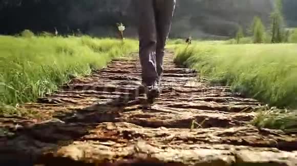 徒步旅行女游客在山上的一座桥上散步徒步探险近距离步行腿前景视频的预览图