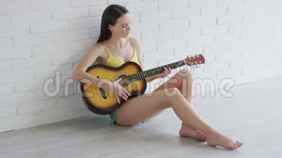 可爱的女人在地板上弹吉他视频的预览图