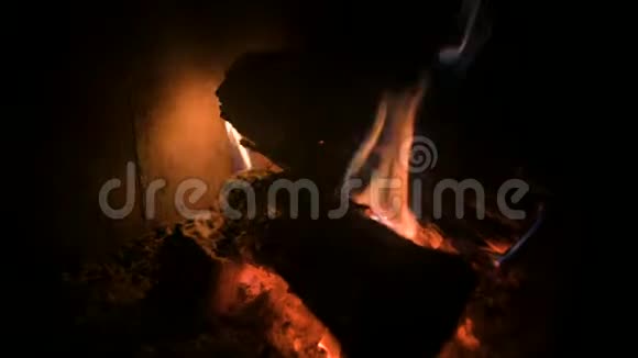 晚上在一个耐火玻璃后面的现代家庭炉子里用煤把昏暗燃烧的木柴特写出来低键视频的预览图