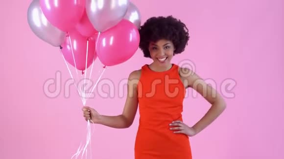 年轻女子工作室被隔离在粉红色女子一天穿着红色连衣裙拿着气球视频的预览图