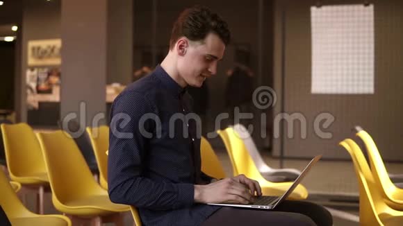 年轻迷人的男性在笔记本电脑上打字工作过程青年教育视频的预览图