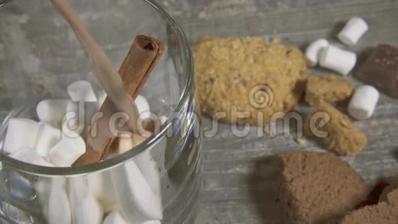 用棉花糖和肉桂倒入可可的透明杯子缓慢移动视频的预览图