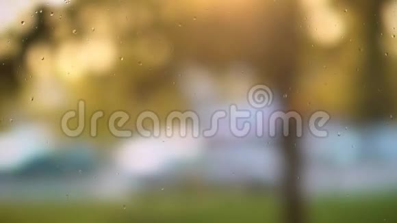 特写雨滴落在窗户上的图像模糊的背景视频的预览图