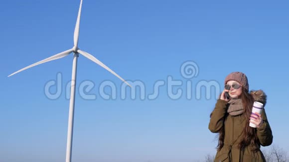 现代科技女孩正在天堂的风力发电站附近打电话视频的预览图