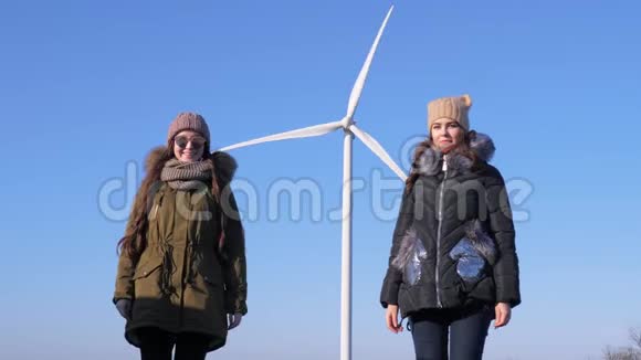 能量转换快乐的朋友在蓝天的风力涡轮机附近玩得开心视频的预览图