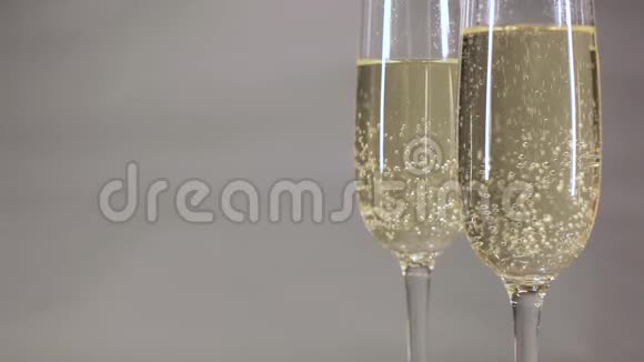 在灰色背景的玻璃中升起的香槟视频的预览图