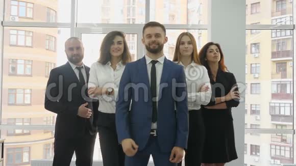 办公室工作人员两名青年男子和三名青年妇女排成一个三角形前景中的一名青年男子展示了视频的预览图