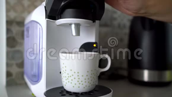 女士准备新鲜咖啡与牛奶家庭胶囊咖啡机视频的预览图