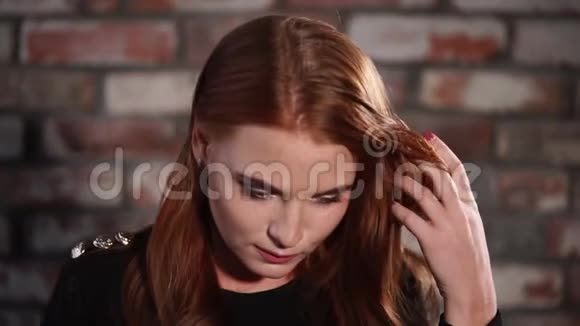 一个漂亮的年轻女人有着化妆和红色的卷发正看着一照相机视频的预览图