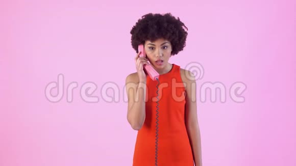 年轻女子工作室与粉红女子隔阂一天穿着红色连衣裙打电话震惊视频的预览图