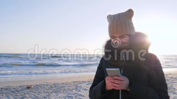 网络通讯女人用手机在海边聊天视频的预览图
