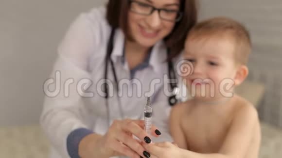 女医生给小男孩看注射器他们玩视频的预览图