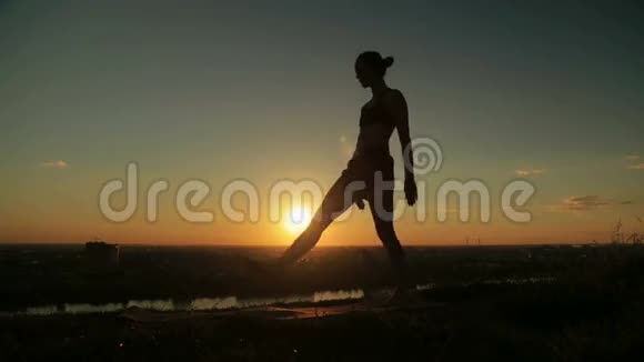 日落时分在公园做阿斯汤加瑜伽的女人视频的预览图