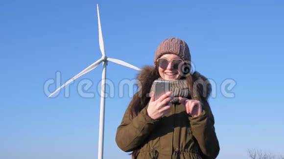网瘾戴眼镜的女人手里拿着手机靠近风站户外天空视频的预览图