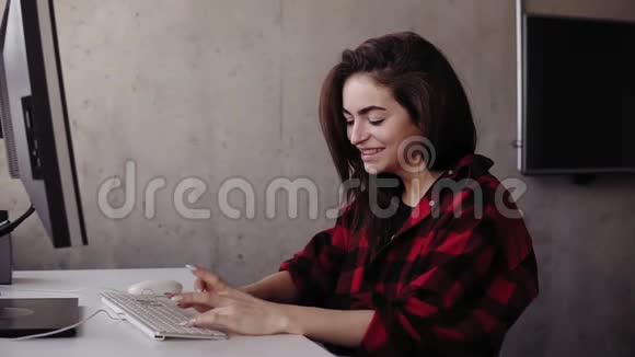 年轻迷人的女孩在键盘上打字时带着真诚的喜悦微笑和笑声视频的预览图