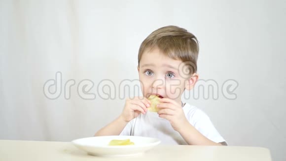 小孩在白色背景下慢动作吃薯片视频的预览图