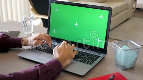 在他的房子里人们在用一台带有绿色屏幕的模拟笔记本电脑工作视频的预览图