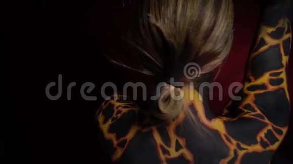 一个女孩在她的身体上画着火山熔岩转过脸向前视频的预览图