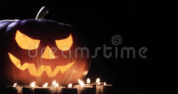 万圣节和假日概念鬼鬼祟祟的杰克灯或雕刻南瓜灯在黑暗中燃烧视频的预览图