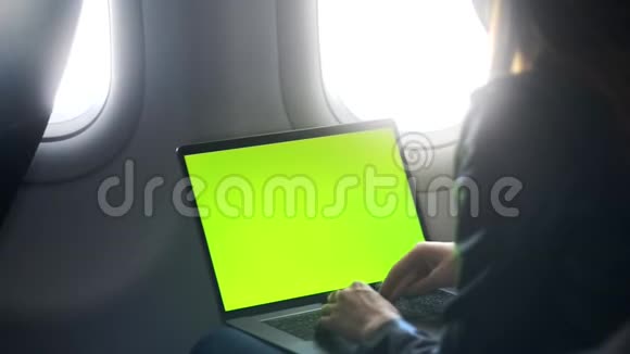 年轻女子在键盘上打字坐在飞机上视频的预览图