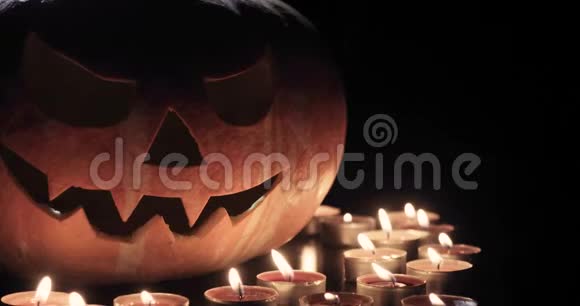 万圣节和假日概念鬼鬼祟祟的杰克灯或雕刻南瓜灯在黑暗中燃烧视频的预览图