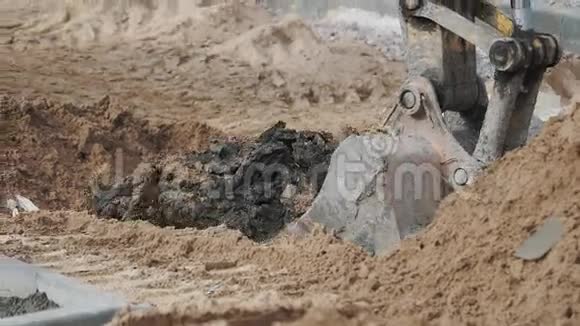 挖掘机铲斗在建筑场地挖土砂土孔慢动作视频的预览图