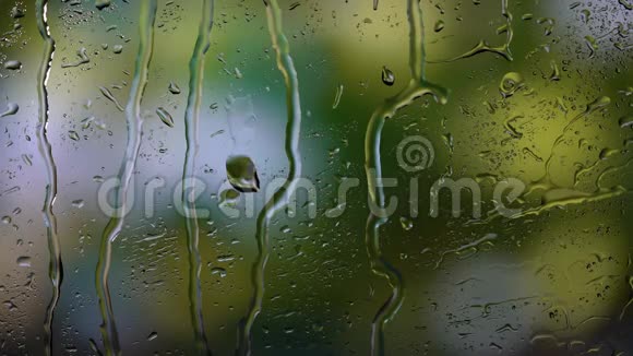 特写雨滴落在窗户上的图像模糊的背景视频的预览图