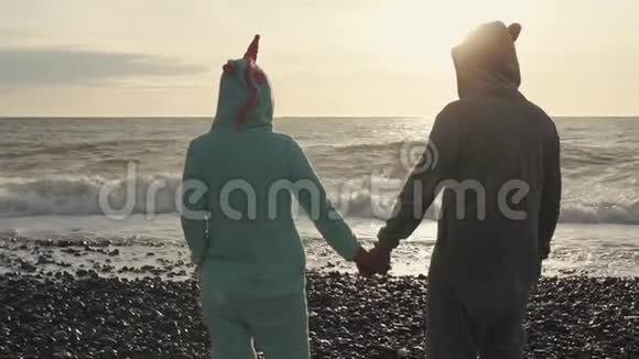 吉古鲁米的男人和女人站在海滩上看海浪视频的预览图