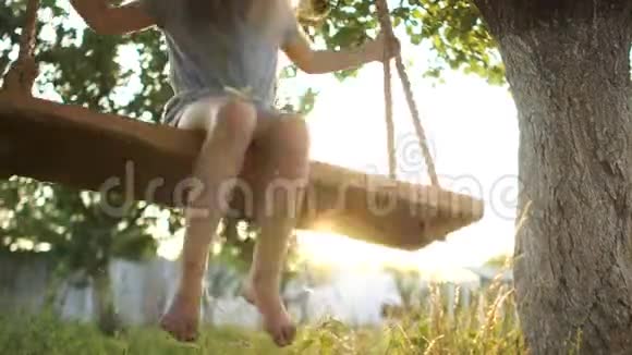 嬉戏挑衅的女孩在秋千上翻滚露出她的舌头在乡村放松暑假快乐视频的预览图