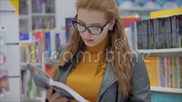肖像特写幸福美丽的年轻女子戴眼镜的女孩在书库大学读书视频的预览图