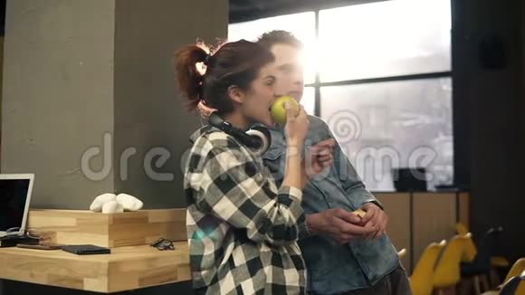 两个年轻快乐的人在一起玩吃苹果享受他们的生活都市时髦女郎视频的预览图