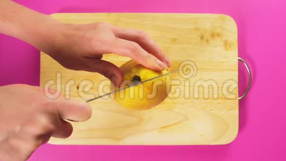 俯视雌手用刀切水果在木板上烂芒果天然健康食品的概念视频的预览图