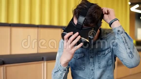 有魅力的年轻人戴上VR耳机开始玩虚拟现实电子游戏休闲时间视频的预览图