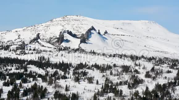 冬天的山在下午的蓝天上白雪皑皑视频的预览图