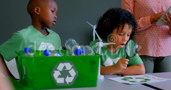 4k教室的学生在课桌上学习绿色能源和回收视频的预览图