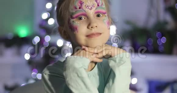 一个可爱的小女孩化妆鲜艳看着相机微笑着视频的预览图