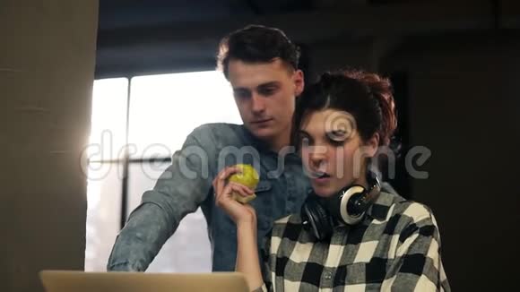 两个年轻人年轻人和一个女孩用笔记本电脑打字一起度过时光开放的共同工作空间视频的预览图